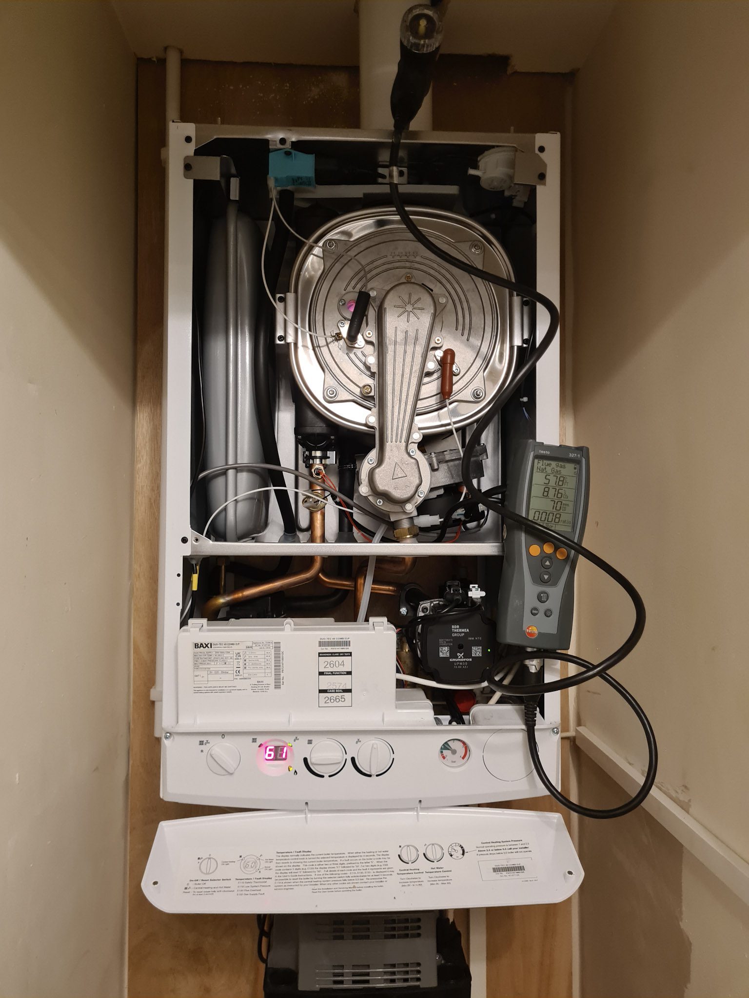 An engineer servicing a Baxi boiler with a flue gas analyser