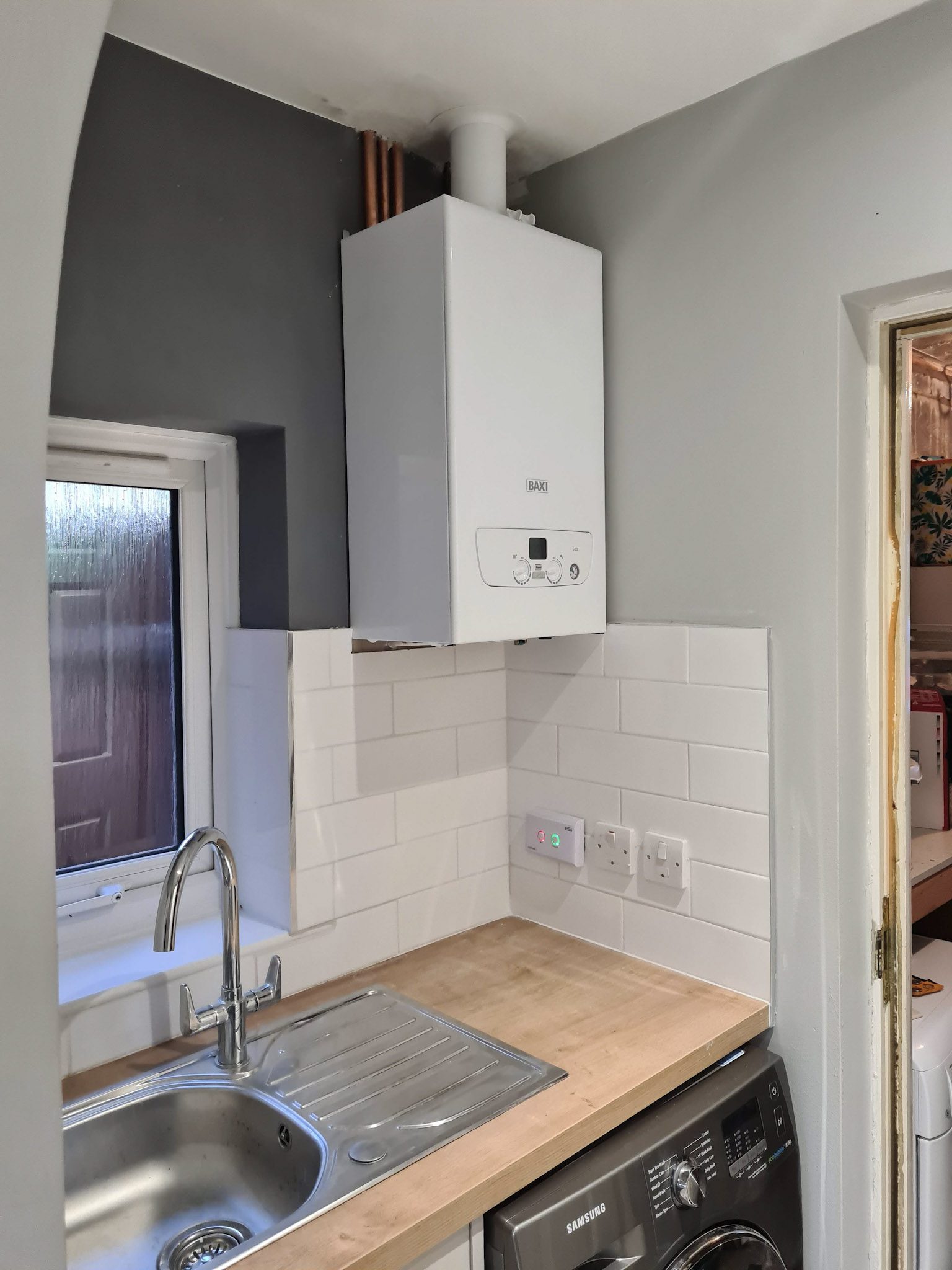 An existing combi boiler above a kitchen worktop